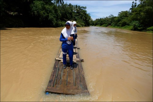 Studenti přeplouvají řeku na provizorní bambus voru, Cilangkap Village, Indonésie (500 x 334)