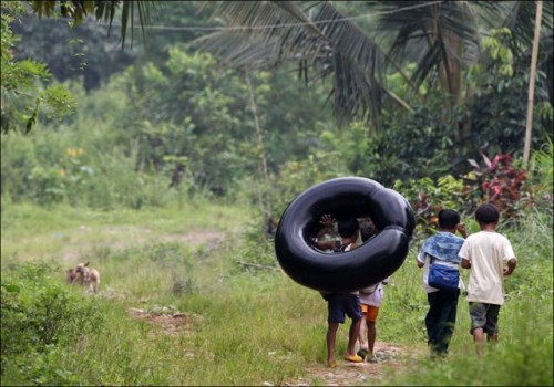 Studenti se dostávají do školy na nahuštěné pneumatice, v provincii Rizal, Filipíny (500 x 350)